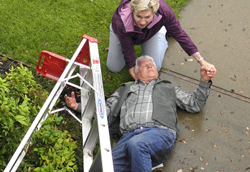 Man fallen down next to ladder getting assistance from wife