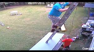 Man climbing a ladder ontop of a folding table